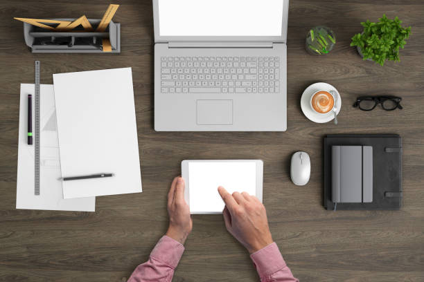 istock Man holding tablet knolling overhead view 959295530