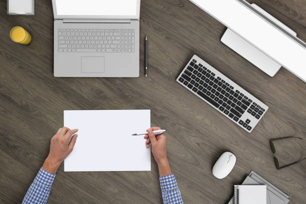 istock Business man writing on a plank paper at an office desk 959295596