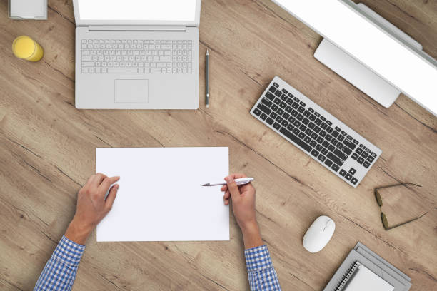 istock Business man writing on a plank paper at an office desk 959295598