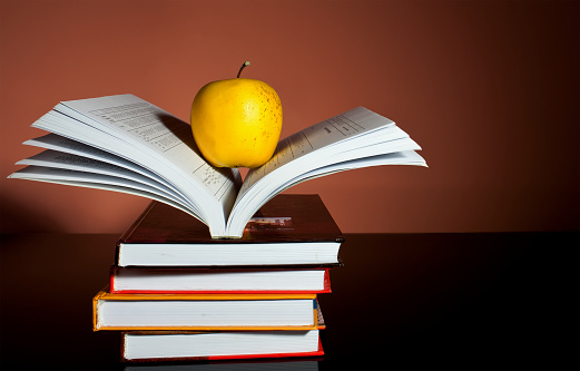 Yellow apple on an open book