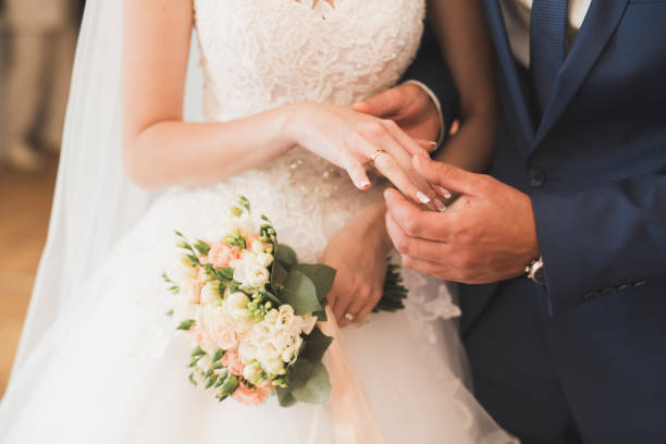 noiva e noivo trocando os anéis de casamento. cerimônia oficial de casal elegante - registry office - fotografias e filmes do acervo