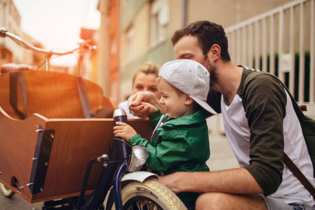 Little boy checking out new family vehicle Photo of a curious little boy, examining new family vehicle - a cargo bicycle cargo bike photos stock pictures, royalty-free photos & images