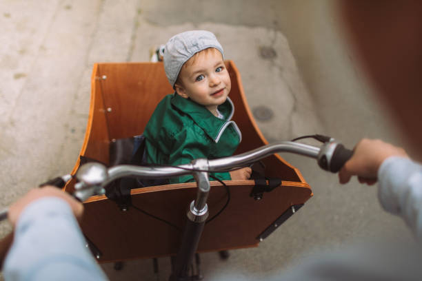 Commuting to kindergarten Photo of a cheerful little boy riding in a cargo bike on his way to kindergarten // first person perspective cargo bike photos stock pictures, royalty-free photos & images
