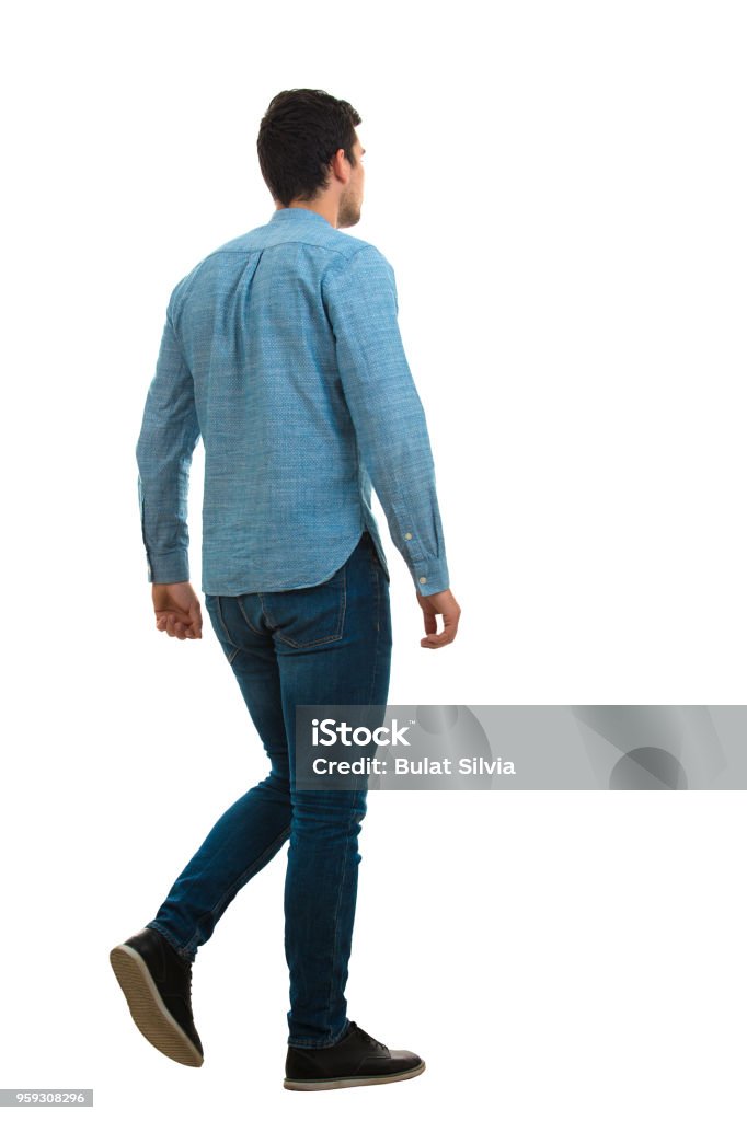 young man walking isolated on white background Full length back portrait of a young man walking isolated on white background. People Stock Photo