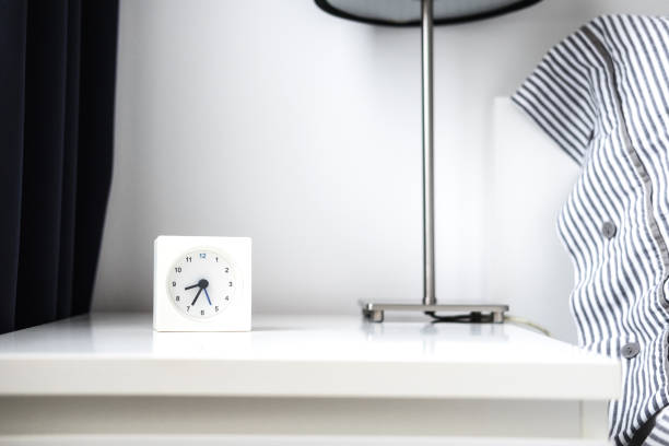 Alarm clock in white bedroom iterior Morning alarm clock in white bedroom interior. Copyspace for text. Minimalist concept night table stock pictures, royalty-free photos & images