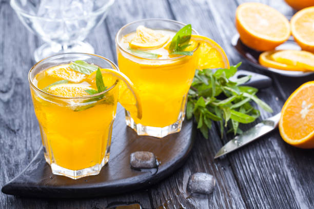 istock orange cocktail with ice and fresh mint on a black wooden table 959319264
