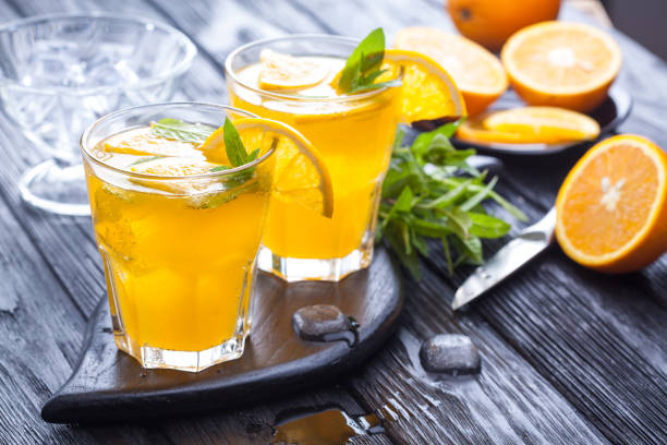 istock orange cocktail with ice and fresh mint on a black wooden table 959319344