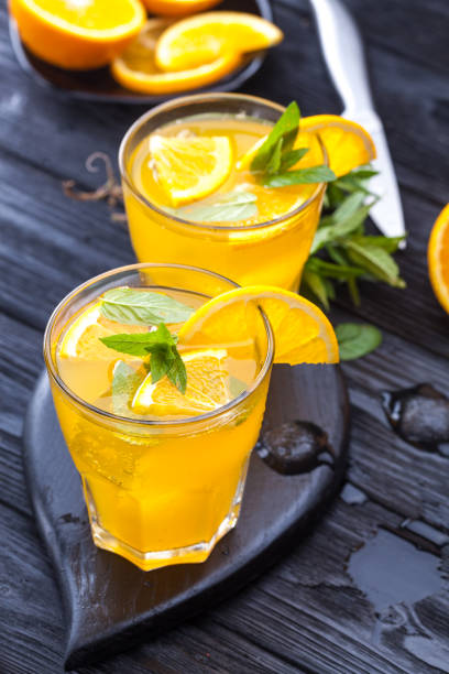 istock orange cocktail with ice and fresh mint on a black wooden table 959319494