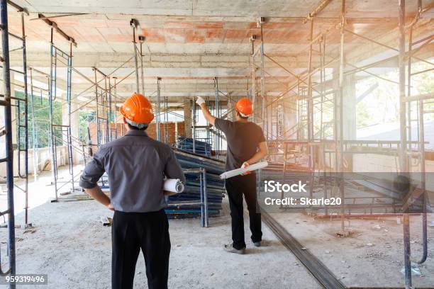 Engineer Discussing With Foreman About Project In Building Construction Site Stock Photo - Download Image Now