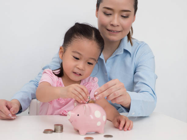 istock mother teach her kid to saving money. 959323832