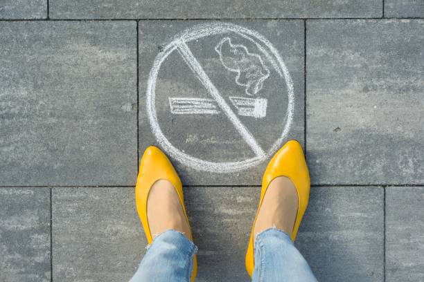 女性の足画像とグレーの歩道に喫煙が描かれてないです。 - smoking smoking issues stop stop sign ストックフォトと画像