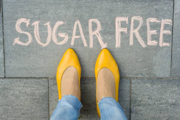 istock Female feet with text sugar free written on grey sidewalk 959324398