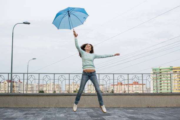 istock The girl is flying with an umbrella 959324924