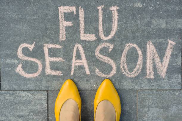 istock Female feet with text flu season written on grey sidewalk 959327982