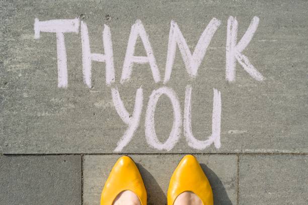 istock Female feet with text thank you written on grey sidewalk 959328190