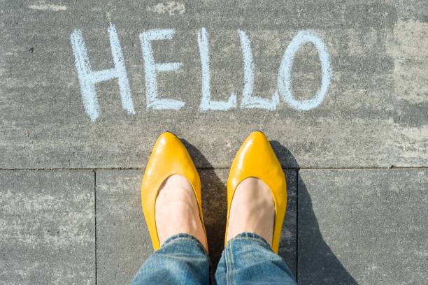 istock Female feet with text hello written on asphalt 959328344