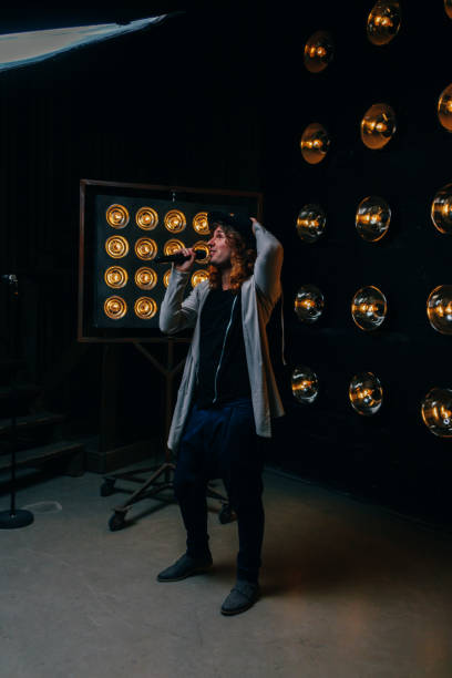 istock men singer with long hair, with microphone on the stage 959332240