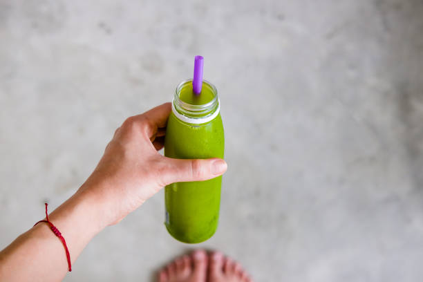 istock Woman's hand holds a bottle of green juice 959336714