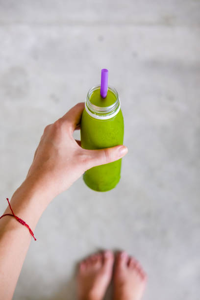istock Woman's hand holds a bottle of green juice 959336732