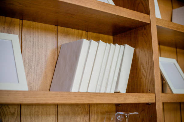 istock shelf with books. White Books, knowledge, education concept. Interior details.Selective focus.Bookshelf.stack of books on the wooden shelves near the wall 959340796