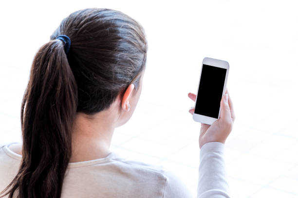 istock young woman looking at the smartphone, isolated on white background 959341512
