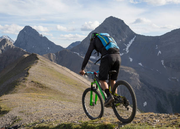 istock Mountain biker traverses high mountain ridge crest 959348034