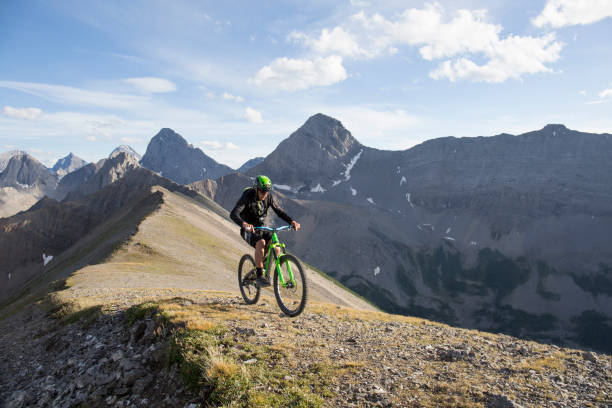 istock Mountain biker traverses high mountain ridge crest 959348040
