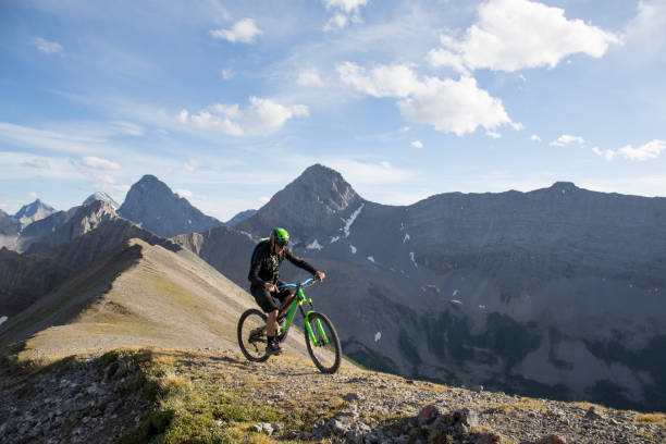 istock Mountain biker traverses high mountain ridge crest 959348056