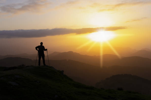istock Hiker on the top of a mountain facing the sun. 959348418