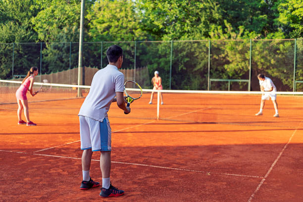 istock Couples playing doubles at the tennis court 959350742