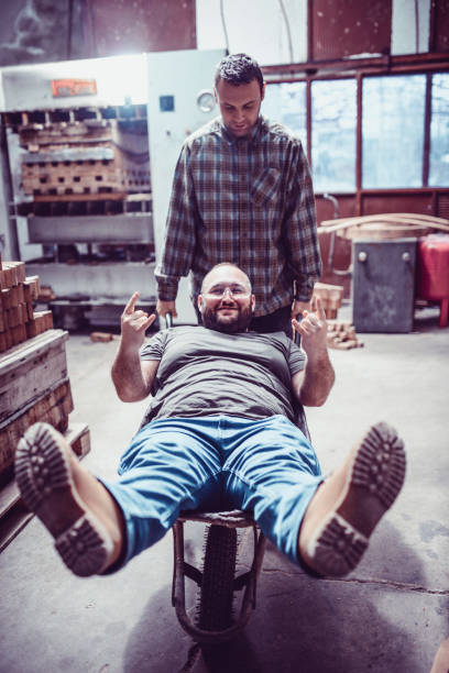 istock Workers Having Fun and Driving with Concrete Trolley in Factory 959351216