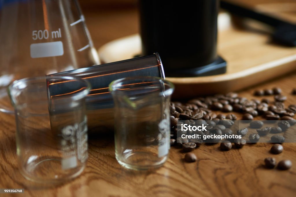 Coffee beans and glassware for coffee preparing on wooden table Coffee beans and glassware for coffee preparing on wooden table, close-up Coffee - Drink Stock Photo