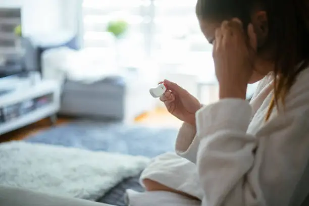 Photo of Woman looking at home pregnancy test