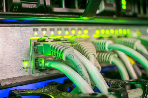 ネットワーク インターネット配線は、サーバー ルーム内のノードのスイッチに接続されます。インターフェイスの緑の照明スイッチ上にあります。選択と集中 - cable network server network connection plug green ストックフォトと画像