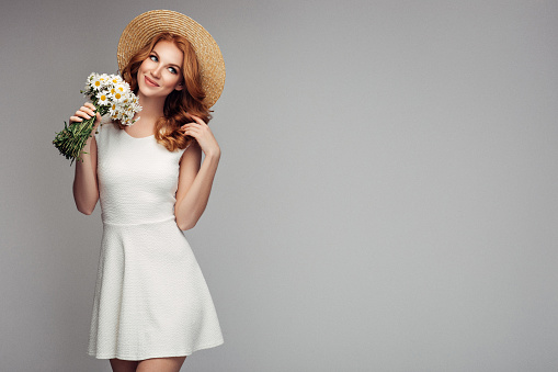 Beautiful woman with red hair holding bouquet