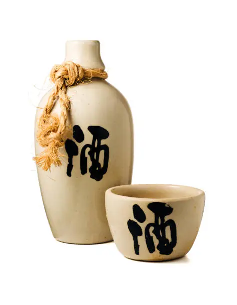 Sake bottle and cup, with the ideogram for "liquor" on both, isolated on white background with clipping path