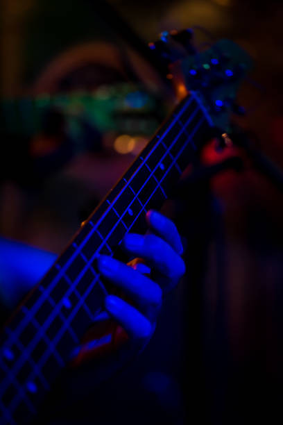 istock Musician playing bass guitar in dim light 959371902
