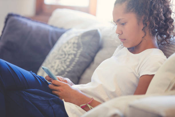Young Aboriginal girl looking upset with mobile phone.