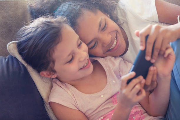 istock Two girls on the sofa looking at a smart phone. 959377134