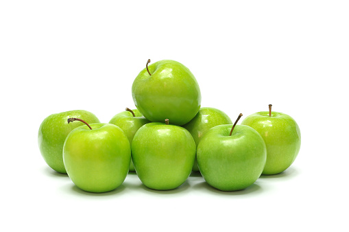 Stack of fresh ripe apples laid on white background.