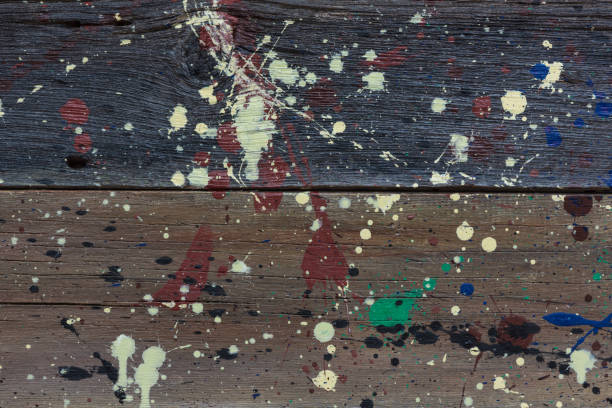 istock Multicolored abstract paint splatters on weathered wooden boards. 959385568