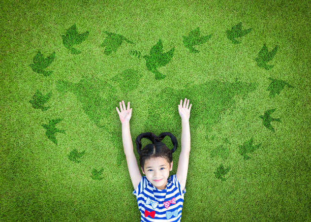 World peace day concept with peaceful mind kid resting in clean natural environment on eco friendly world map green lawn World peace day concept with peaceful mind kid resting in clean natural environment on eco friendly world map green lawn dove bird photos stock pictures, royalty-free photos & images