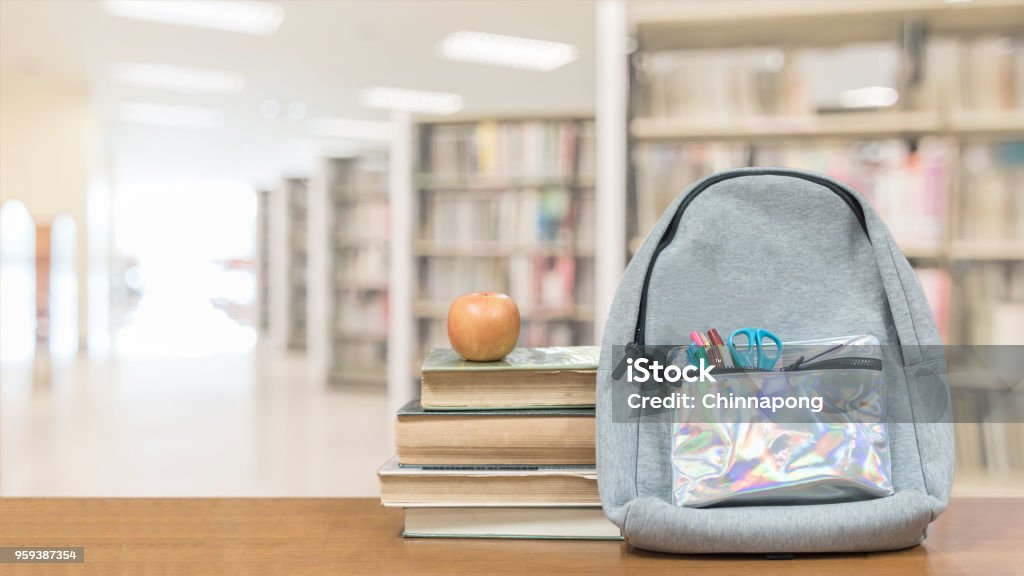 Back to school concept with school books, textbooks, backpack and stationery supplies on classroom desk with library or class background for educational new academic year begin or study term start Greeting Stock Photo