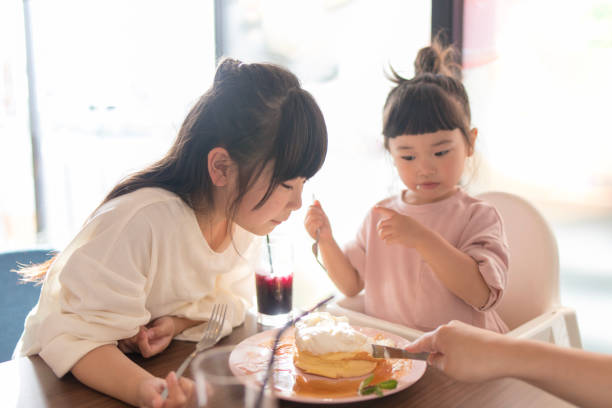 istock Little sisters happy eating pancake at cafe 959390634