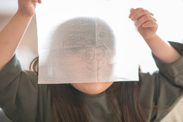Little girl making a face with her drawing