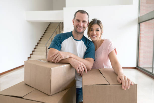 istock Happy couple moving house and packing in boxes 959398752