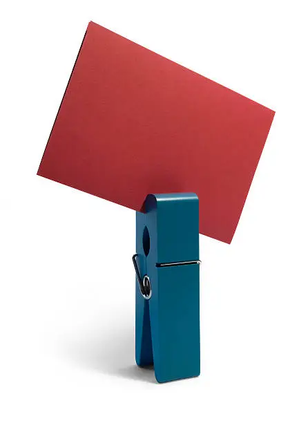 Studio photography of a standing blue peg holding a red card, isolated on white with shadow 