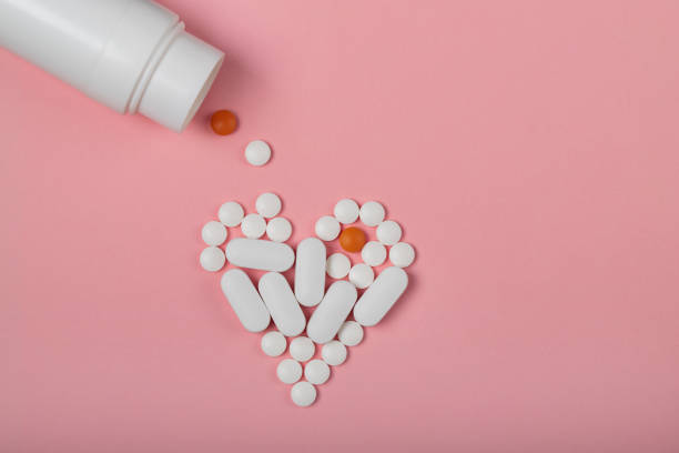 istock round and oval white pills on a pink background 959407306