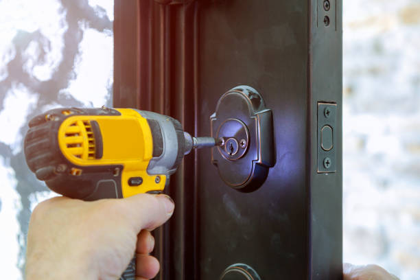istock Install the door handle with a lock, Carpenter the screw, using an drill screwdriver, close-up. 959410844