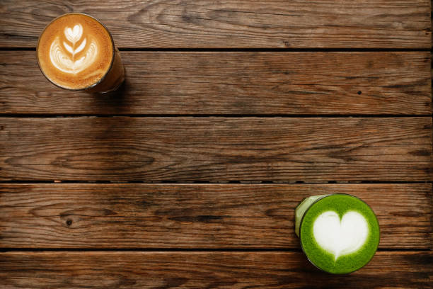 A cup of green tea matcha latte and cup of latte art coffee